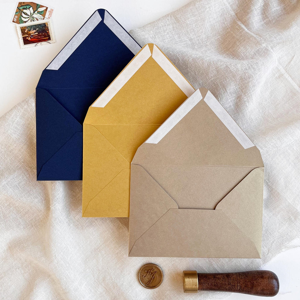 Three RSVP envelopes shown open – Navy Blue Matt, Gold Metallic, and Old Gold Metallic – with a ribbon closure that is easy to open and reseal.